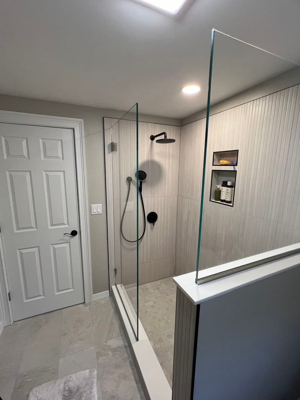 Modern glass shower enclosure with minimalist design and sleek fixtures in a bathroom setting.